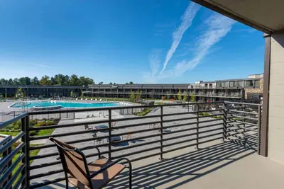 a balcony with a chair and a swimming pool at Wyndham Lancaster Resort and Convention Center in Lancaster
