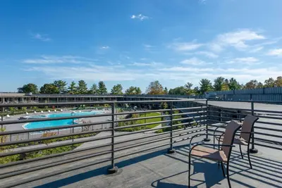 a balcony with two chairs and a swimming pool at Wyndham Lancaster Resort and Convention Center in Lancaster
