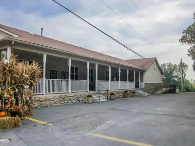 an older building with a white fence and a building at Appalachian Camping Resort Cottage 1 in Shartlesville