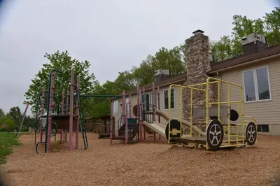 a playground in front of a house at Appalachian Camping Resort Park Model 2 in Shartlesville