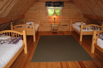 a room with two beds in a log cabin at Appalachian Camping Resort Log Home 6 in Shartlesville