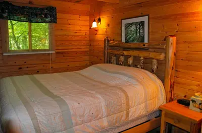 a bedroom with a bed in a log cabin at Appalachian Camping Resort Log Home 6 in Shartlesville