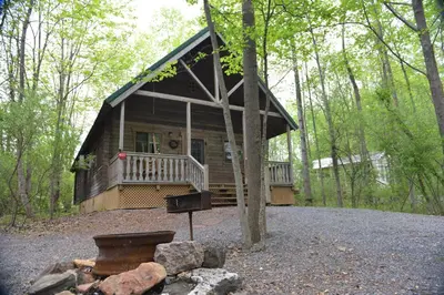 a log cabin with a grill in front of it at Appalachian Camping Resort Log Home 6 in Shartlesville