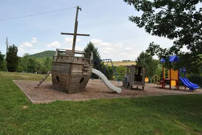 a park with a playground with a cross on it at Robin Hill Camping Resort Premium Cottage 1 in Lenhartsville