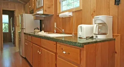 a kitchen with a counter with a sink and a refrigerator at Robin Hill Camping Resort Premium Cottage 1 in Lenhartsville