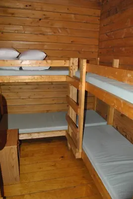 a room with three bunk beds in a cabin at Robin Hill Camping Resort Two-Bedroom Cottage 6 in Lenhartsville