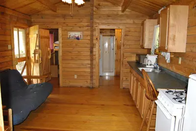 a kitchen in a log cabin with a stove at Robin Hill Camping Resort Two-Bedroom Cottage 6 in Lenhartsville