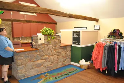 a man standing at the counter of a clothing store at Robin Hill Camping Resort Premium Cottage 9 in Lenhartsville
