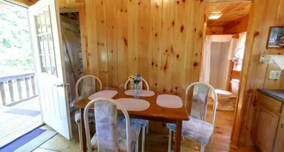 a wooden dining room with a table and chairs at Robin Hill Camping Resort Deluxe Cottage 13 in Lenhartsville