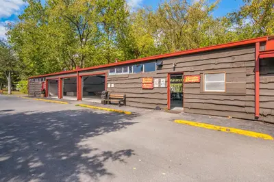 a wooden building with a bench in front of it at Rondout Valley Camping Resort Deluxe Park Model 11 in Accord