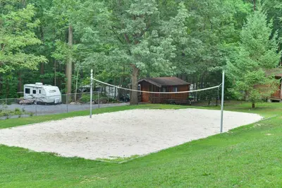 a volleyball court with a net in a yard at Sun Valley Campground Cottage 6 in Maple Grove Park