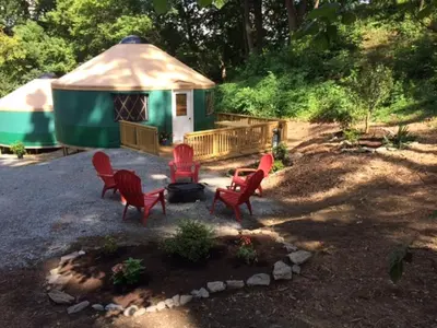 a gazebo with red chairs and a grill in a yard at Circle M Camping Resort Yurt in Lancaster