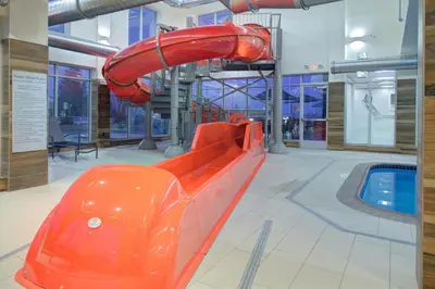 an orange slide in a building with a pool at Fairfield Inn & Suites by Marriott Allentown West in Breinigsville