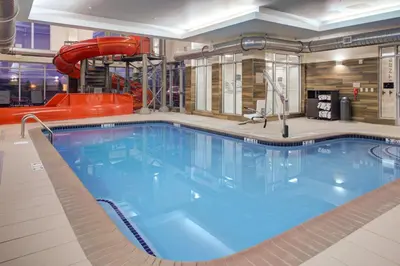 a large swimming pool with a slide in a building at Fairfield Inn & Suites by Marriott Allentown West in Breinigsville