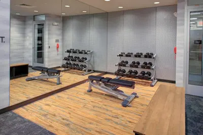 a gym with a row of benches and weights at Fairfield Inn & Suites by Marriott Allentown West in Breinigsville