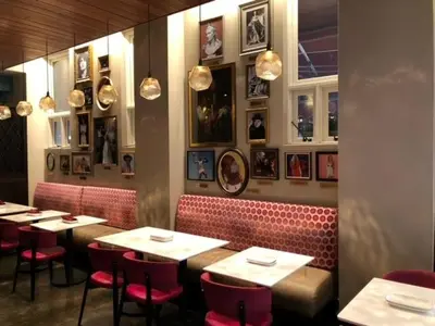 a restaurant with tables and red chairs and pictures on the wall at Fairfield Inn & Suites by Marriott Philadelphia Downtown/Center City in Philadelphia