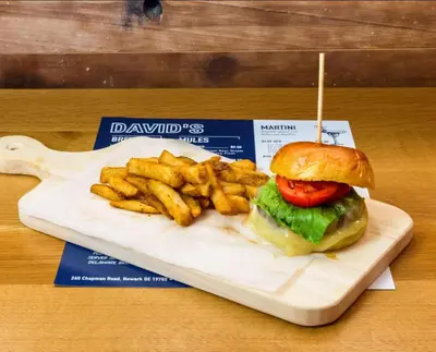 a plate with a sandwich and french fries on a table at Ramada by Wyndham Newark/Wilmington in Newark