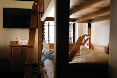 a man laying on a bunk bed taking a picture in a mirror at Freehand New York in New York
