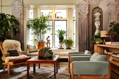 a living room filled with furniture and plants at Freehand New York in New York