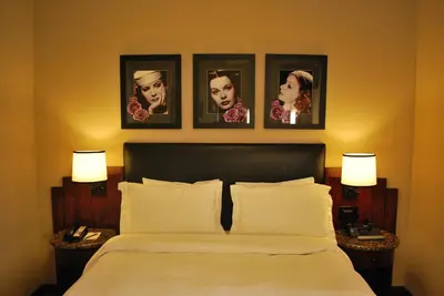 a bedroom with a bed with four pictures on the wall at Washington Square Hotel in New York