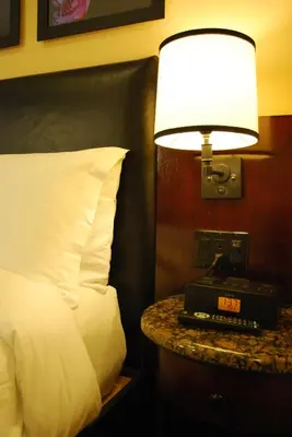a bedroom with a bed and a lamp on a table at Washington Square Hotel in New York