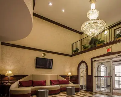 a living room with a couch and a chandelier at Quality Suites NYC Gateway in North Bergen
