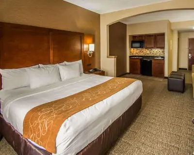 a hotel room with a large bed and a kitchen at Quality Suites NYC Gateway in North Bergen
