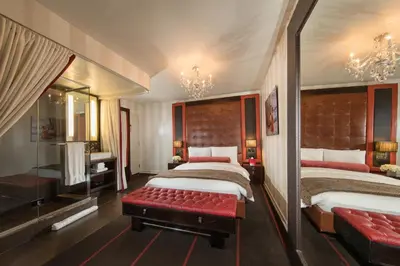a bedroom with two beds and a red bench at Sanctuary Hotel New York in New York