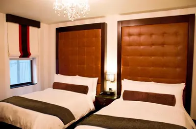 a bedroom with two beds and a chandelier at Sanctuary Hotel New York in New York