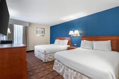 a hotel room with two beds and a television at SureStay Hotel by Best Western East Brunswick in East Brunswick