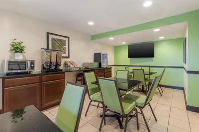 a conference room with a table and chairs and a microwave at SureStay Hotel by Best Western East Brunswick in East Brunswick