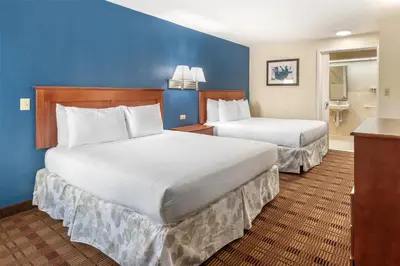 two beds in a hotel room with blue walls at SureStay Hotel by Best Western East Brunswick in East Brunswick