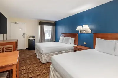 a hotel room with two beds and a blue wall at SureStay Hotel by Best Western East Brunswick in East Brunswick