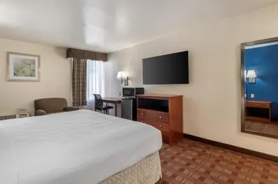 a hotel room with a bed and a flat screen tv at SureStay Hotel by Best Western East Brunswick in East Brunswick