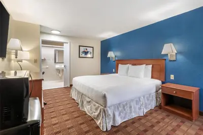 a bedroom with a large bed and a blue wall at SureStay Hotel by Best Western East Brunswick in East Brunswick