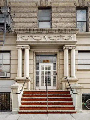 a building with a white door and stairs in front at Central Park West Hostel in New York