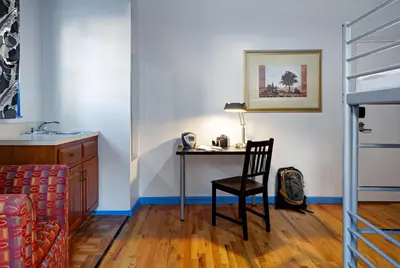 a room with a desk with a chair and a lamp at Central Park West Hostel in New York