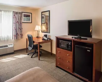 a hotel room with a desk and a flat screen tv at Quality Inn New Columbia-Lewisburg in New Columbia
