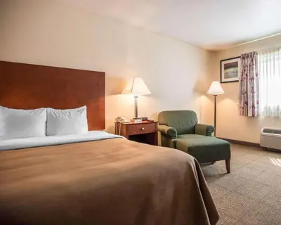 a hotel room with a bed and a chair at Quality Inn New Columbia-Lewisburg in New Columbia