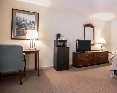 a hotel room with a television and a desk with a mirror at Quality Inn New Columbia-Lewisburg in New Columbia