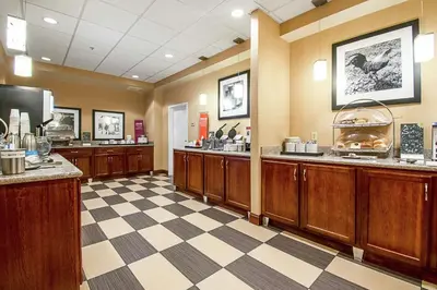 a waiting room with wooden cabinets and a checkered floor at Hampton Inn Pine Grove in Pine Grove