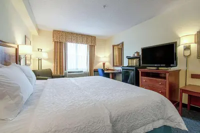 a hotel room with a bed and a flat screen tv at Hampton Inn Pine Grove in Pine Grove