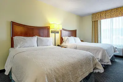 a hotel room with two beds and a window at Hampton Inn Pine Grove in Pine Grove