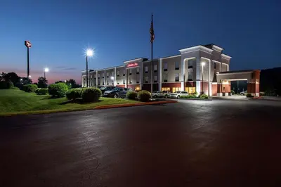 a large white building with cars parked in a parking lot at Hampton Inn Pine Grove in Pine Grove