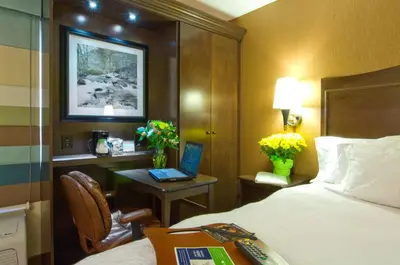 a hotel room with a bed and a desk with a laptop at Hampton Inn Downingtown/Exton in Exton