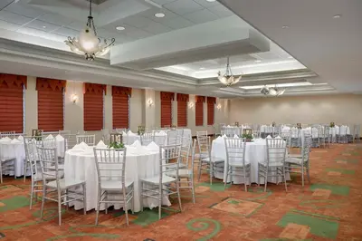 a banquet hall with white tables and chairs and chandeliers at Hampton Inn Easton in Easton