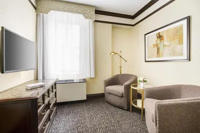 a hotel room with a tv and a chair and a table at Hotel Lucerne in New York