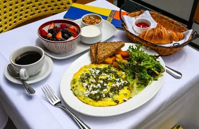 a table topped with an omelet and a plate of breakfast food at Hotel Lucerne in New York