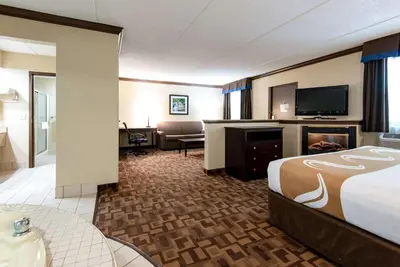 a hotel room with a bed and a flat screen tv at Quality Inn & Suites Quakertown-Allentown in Quakertown