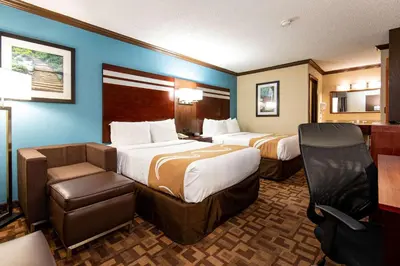 a hotel room with two beds and a chair at Quality Inn & Suites Quakertown-Allentown in Quakertown